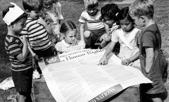 أرشيف: أطفال يمسكون بورقة ضخمة مكتوب عليها الإعلان العالمي لحقوق الإنسان الذي اعتمد عام 1948